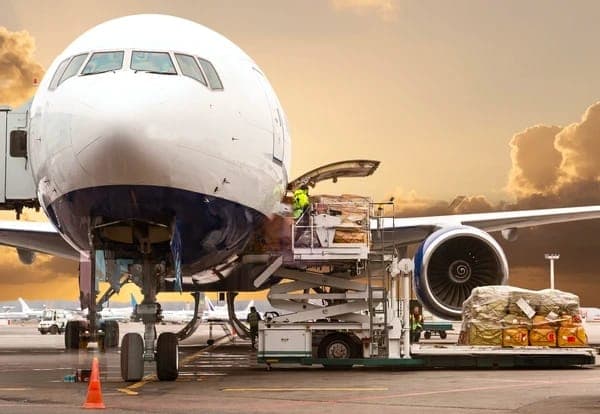 Freight being loaded into an aircraft at sunset